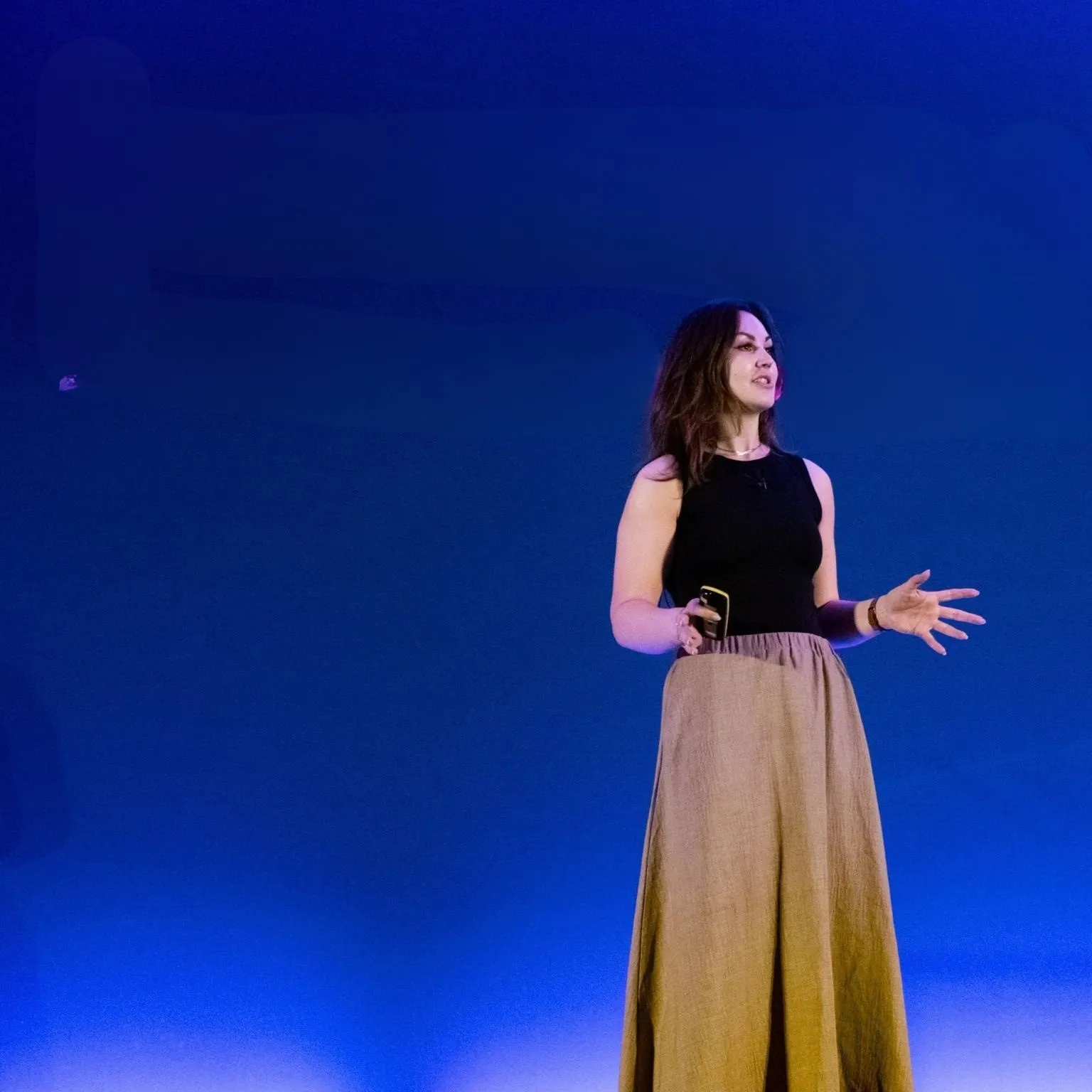 Eryn Peters on stage against a deep blue backdrop