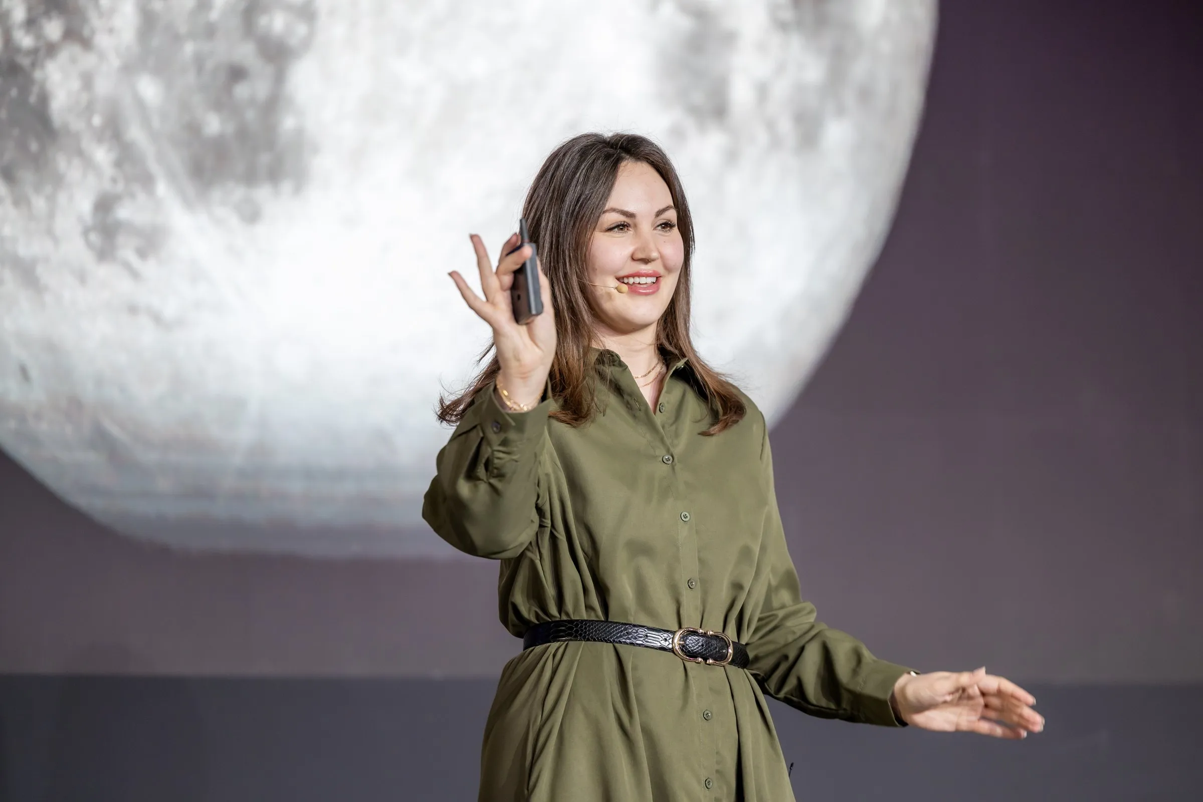 Eryn Peters speaking on stage in front of a giant moon